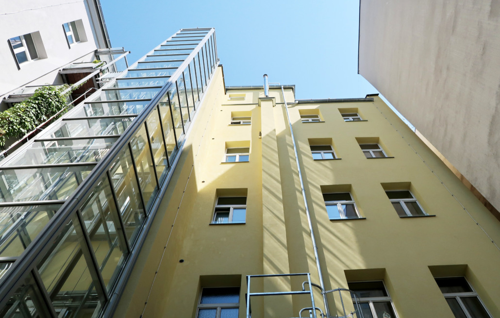 Ein Hinterhof eines sanierten Altbaus mit Fahrstuhlschacht